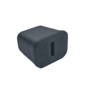 K&ouml;nnte beinhalten: Ein schwarzer Kunststoffstecker mit rechteckiger Form und einem einzigen runden Loch in der Mitte.