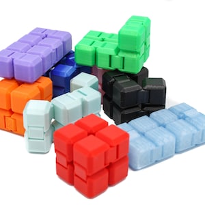 May include: A set of nine colorful interlocking puzzle cubes. The cubes are made of plastic and are in various colors, including purple, orange, green, blue, black, and red.