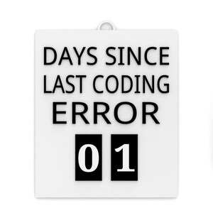 Könnte beinhalten: Ein weißes Schild mit dem Text "DAYS SINCE LAST CODING ERROR" in Schwarz. Darunter zeigen zwei schwarze Kästchen die Zahl "01" in Weiß. Das Schild hat oben eine kleine Schlaufe zum Aufhängen.