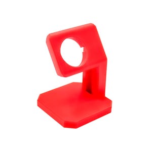May include: A bright red plastic stand for a smartwatch. The stand has a square base and a raised arm with a circular cutout for the watch face.
