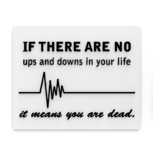 May include: White rectangular sign with black text: "IF THERE ARE NO ups and downs in your life it means you are dead." A black line graphic represents a heartbeat.
