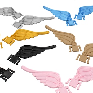 May include: Set of ten pairs of plastic angel wings in various colors, including black, white, gold, pink, blue, and brown. The wings are designed to be attached to shoes or other items.