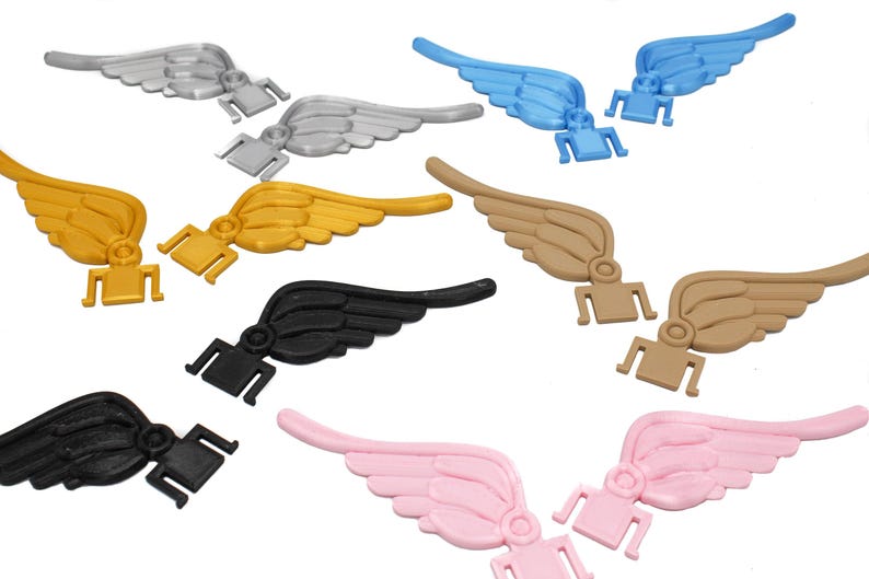 May include: Set of ten pairs of plastic angel wings in various colors, including black, white, gold, pink, blue, and brown. The wings are designed to be attached to shoes or other items.
