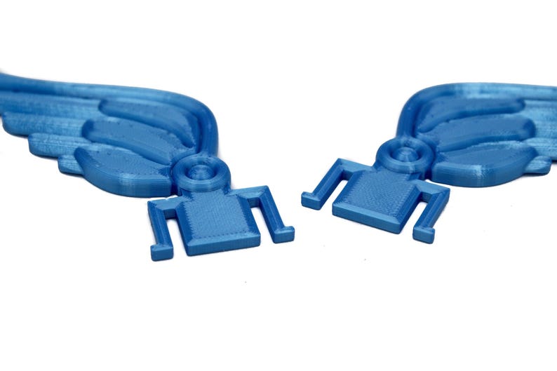 May include: Two blue plastic wings with a textured surface and a small, square base. The wings are designed to be attached to a larger object.