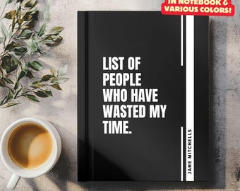 May include: Black journal with white text that reads "List of People Who Have Wasted My Time." The journal has a white spine with the name "Jane Mitchells" printed vertically. The text "Also Available in Notebook & Various Colors!" is printed in red on a white rectangle.