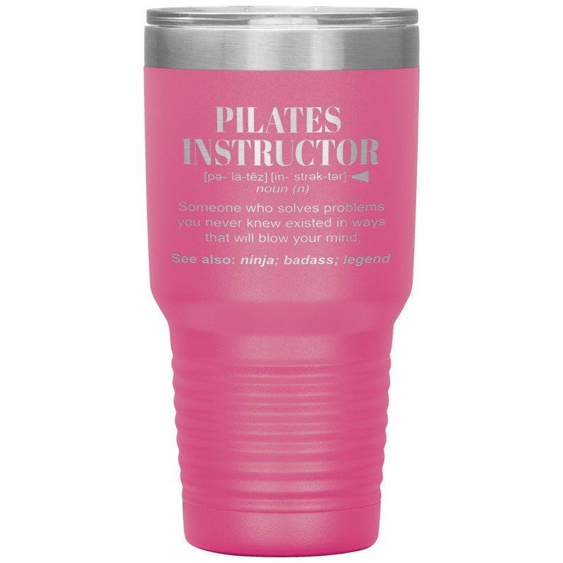 May include: A pink stainless steel tumbler with a silver lid. The tumbler has a white inscription that reads "PILATES INSTRUCTOR [pa- l&auml;-tēz] [in- strək-tər] noun (n) Someone who solves problems you never knew existed in ways that will blow your mind. See also: ninja; badass; legend"