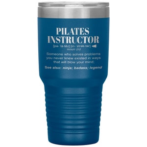 May include: A blue stainless steel tumbler with a white inscription that reads "PILATES INSTRUCTOR [pə-l&auml;-tēz] [in- strək-tər] noun (n) Someone who solves problems you never knew existed in ways that will blow your mind; See also: ninja; badass; legend"