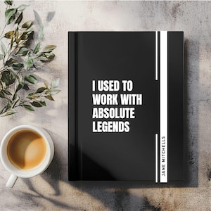 May include: A black notebook with the text "I USED TO WORK WITH ABSOLUTE LEGENDS" in white. A white vertical stripe runs down the right side, with "JANE MITCHELLS" in white. A cup of coffee and greenery are in the background.