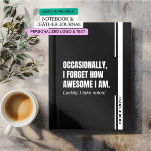 May include: Black notebook with the text "OCCASIONALLY, I FORGET HOW AWESOME I AM. Luckily, I take notes!" and the name "BOBBIE SMITH". The notebook has a white stripe on the right side. A cup of coffee and greenery are also in the image.