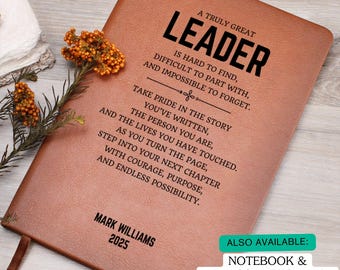 May include: A brown leather journal with the text "A Truly Great Leader" and inspirational quotes. The journal includes the name "Mark Williams" and the year "2025". A ribbon bookmark is visible.