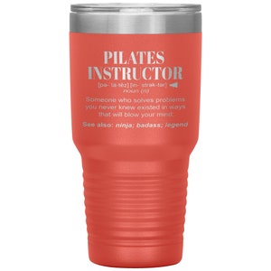May include: A red and silver stainless steel tumbler with the text "PILATES INSTRUCTOR" and a definition of the word. The text is in white and the background is a bright red.