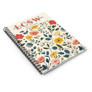 K&ouml;nnte beinhalten: Ein spiralgebundenes Notizbuch mit cremefarbenem Einband, verziert mit einem Blumenmuster aus roten, gelben, rosafarbenen und blauen Bl&uuml;ten sowie gr&uuml;nen Bl&auml;ttern. Der Text "LCSW Licensed Social Worker" und "ANNIE MATTHEWS" ist rot und blau.