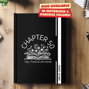 May include: Black notebook with white text that reads "CHAPTER 50 Tips, Tricks & Life Hacks" and "EMILIA JONES". The notebook has a white floral design with a book underneath the flowers.