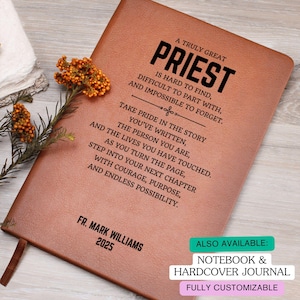 May include: A brown leather journal with the words "A Truly Great Priest" in black. The journal includes inspirational text and the name "Fr. Mark Williams 2025". A ribbon bookmark is visible.