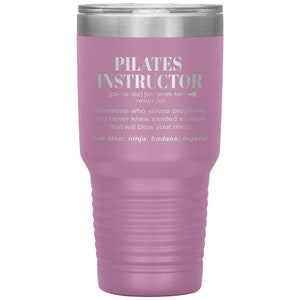 May include: A pink stainless steel tumbler with a silver lid. The tumbler has a definition of "Pilates Instructor" with the phonetic pronunciation and a description of the role.