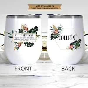 May include: White insulated wine tumbler with a silver rim. The front features text that reads "CHIEF RESIDENT" and a quote, with floral and leaf accents. The back has the name "COLLEEN" and similar floral design. The text "ALSO AVAILABLE IN VARIOUS COLORS AND SIZES" is at the top.