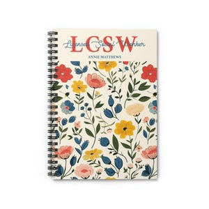 K&ouml;nnte beinhalten: Spiralgebundenes Notizbuch mit floralem Muster. Das Cover zeigt einen cremefarbenen Hintergrund mit bunten Blumen und gr&uuml;nen Bl&auml;ttern. Der obere Teil des Notizbuchs zeigt den Text "LCSW" in Rot und "Licensed Social Worker" in Blau, darunter der Name "Annie Matthews".