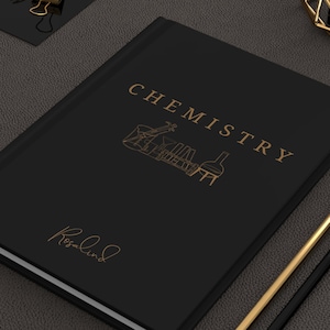 Peut inclure: Un carnet noir avec le mot "CHIMIE" en lettres dorées. Le carnet a une illustration dorée d'équipements de laboratoire et le mot "Rosalind" en écriture cursive dorée.