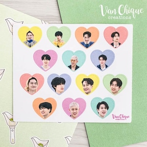 May include: A sheet of stickers featuring 12 heart-shaped stickers with different colored borders. Each sticker has a photo of a different person inside the heart. The stickers are arranged in four rows of three. The text "Van Chique creations" appears at the top of the sheet.