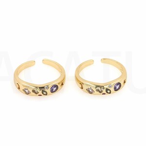 May include: Two gold toe rings with colourful gemstones. The rings are open and adjustable.