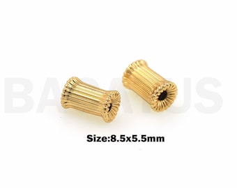 May include: Two gold-colored metal beads with a ribbed texture. The beads are approximately 8.5 mm by 5.5 mm in size.  Size: 8.5x5.5mm