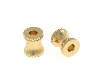 Könnte beinhalten: Zwei goldfarbene Metallperlen mit einem strukturierten Design. Die Perlen haben ein rundes Loch in der Mitte.