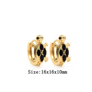 May include: Gold hoop earrings with a black turtle charm. Size: 16x16x10mm.