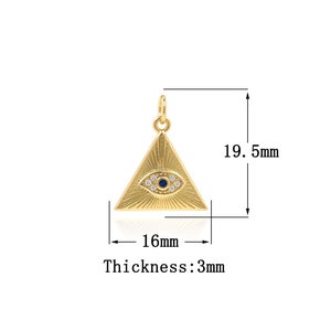 Puede incluir: Colgante de triángulo dorado con un diseño de ojo malvado. El ojo es azul con detalles blancos. El colgante mide 16 mm de ancho y 19,5 mm de alto. El grosor es de 3 mm.