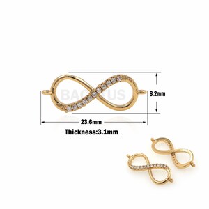 May include: Gold infinity charm with clear crystal accents. The charm measures 23.6 mm wide and 8.2 mm high. The thickness is 3.1 mm.