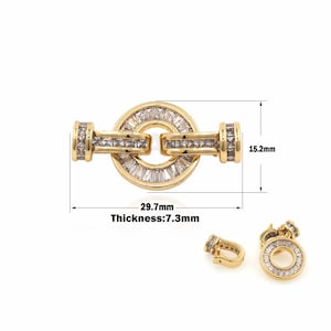 May include: Gold-tone clasp with clear baguette-shaped crystals. The clasp measures 29.7 mm in length, 15.2 mm in width, and 7.3 mm in thickness.