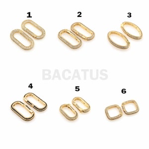 Puede incluir: Seis pares de cierres de metal dorado con piedras transparentes o negras. Cada cierre tiene forma ovalada o cuadrada y tiene una abertura con bisagra. Los cierres están etiquetados con los números del 1 al 6.