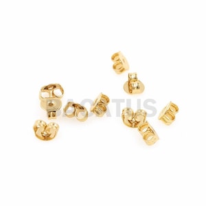 Può includere: Un gruppo di dieci dorsi per orecchini dorati. I dorsi sono progettati per fissare gli orecchini al lobo dell'orecchio.