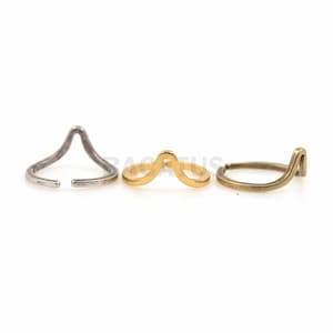 May include: Three minimalist rings with a unique wave design. The rings are made of silver, gold, and brass.