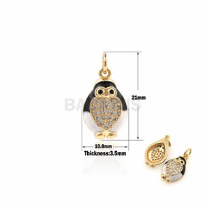 May include: Gold-tone penguin charm with black and white enamel and clear crystal accents. The charm is 2.1 cm tall and 1.08 cm wide. Thickness is 0.35 cm.