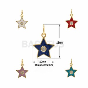 Può includere: Cinque ciondoli a forma di stella dorati con smalto e un cristallo trasparente al centro. I ciondoli sono disponibili in rosso, bianco, blu, rosa e turchese. I ciondoli sono alti 16 mm e larghi 10 mm. Lo spessore è di 2 mm.