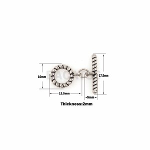 May include: Silver-toned metal toggle clasp with a twisted rope design. The clasp measures 1.75 inches long, 1.35 inches wide, and 0.2 inches thick.
