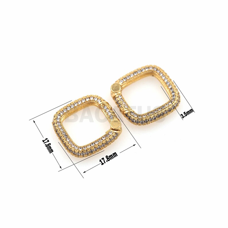 May include: Two gold-toned square-shaped clasps with clear crystal embellishments. Each clasp measures 1.78 inches by 1.78 inches and 0.35 inches in width.