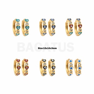 May include: Gold hoop earrings with a heart design and an evil eye charm. The earrings are available in three color combinations: blue, red, and black. Size: 1.3 x 1.4 x 0.3 inches.