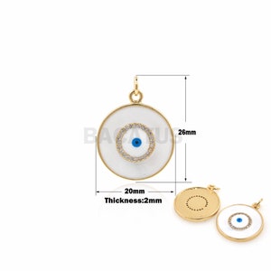 Peut inclure: Pendentif en or avec un mauvais œil en émail blanc et des strass transparents. Le pendentif mesure 20 mm de diamètre et 2 mm d'épaisseur.
