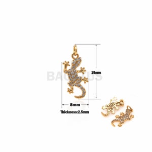 May include: Gold-tone pendant charm featuring a detailed gecko design with clear rhinestones. The charm measures 19 mm in height and 8 mm in width. The thickness is 2.5 mm.