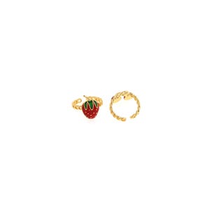 Pu&ograve; includere: Due anelli color oro. Un anello presenta una fragola rossa con foglie verdi. L'altro anello &egrave; una semplice fascia dorata con un design intrecciato. Entrambi gli anelli sono regolabili.