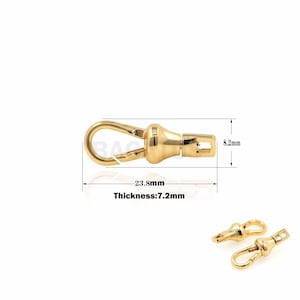 May include: Gold-toned metal clasp with a swivel hook and a round, textured knob. The clasp measures 23.8 mm in length, 8.2 mm in width, and 7.2 mm in thickness.