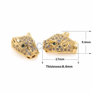 Puede incluir: Encanto de metal dorado con un diseño detallado de cabeza de pantera. El encanto está adornado con diamantes de imitación transparentes y verdes. El encanto mide 17 mm de largo y 8,4 mm de grosor.