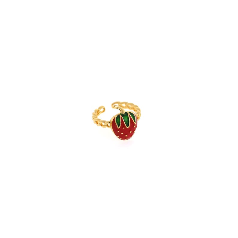 Pu&ograve; includere: Anello dorato con una fragola rossa e foglie verdi. L'anello regolabile ha un design a fascia intrecciata. La fragola &egrave; rifinita con dettagli bianchi e una finitura lucida, creando un accessorio affascinante.