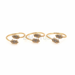 Puede incluir: Tres anillos de oro con un diseño de doble punta. Cada punta está engastada con piedras de circonita cúbica transparentes.