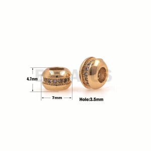 May include: Gold-toned bead with clear crystal accents. The bead measures 0.7 inches in diameter and has a 0.35 inch hole. Hole: 3.5mm