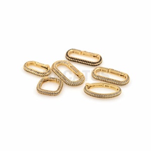 May include: A set of six gold-toned metal clasps with clear crystal embellishments. The clasps are oval and rectangular in shape.