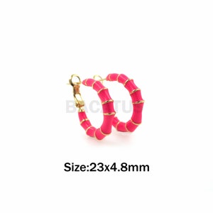 Peut inclure: Une paire de boucles d'oreilles créoles roses avec un motif en bambou doré. Les boucles d'oreilles mesurent 23 mm de diamètre et 4,8 mm de largeur. Taille : 23x4,8 mm