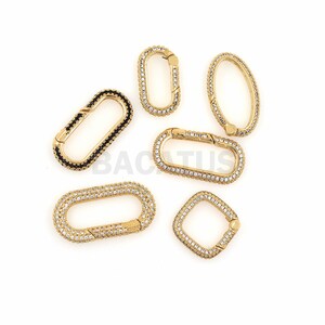 May include: Six gold-toned metal clasps with clear and black crystal embellishments. The clasps are oval and rectangular in shape.
