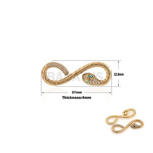 Op de afbeelding: Gouden slangenbedel met groene en witte stenen, 37 mm lang en 12,8 mm breed. De bedel is 4 mm dik.